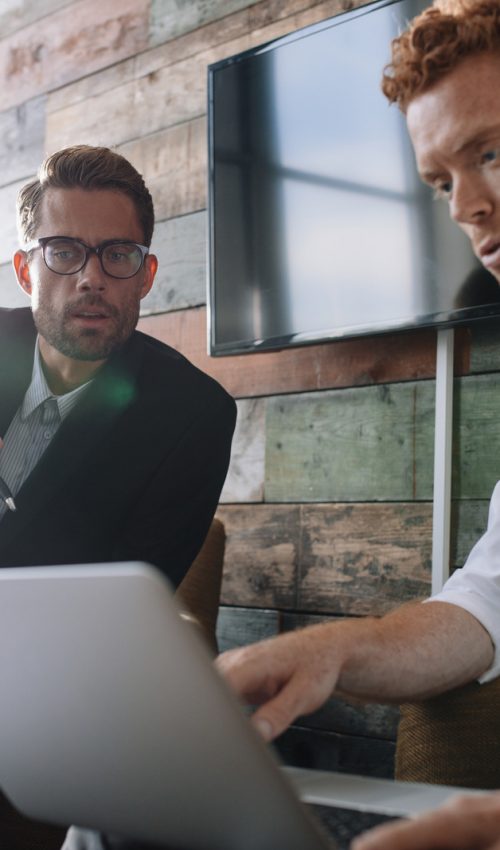 Business colleagues working on laptop during meeting